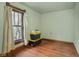 Neutral bedroom featuring hardwood floors, a window, and minimalist decor at 25 N Wayburn St, Indianapolis, IN 46229