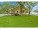 Well-maintained yellow home with a spacious lawn and a charming white picket fence at 25 N Wayburn St, Indianapolis, IN 46229
