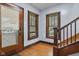 Inviting foyer featuring hardwood floors, detailed window trim, and a staircase leading to the upper levels of the home at 25 N Wayburn St, Indianapolis, IN 46229