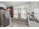Functional kitchen with stainless steel appliances, gray cabinets, granite countertops, and a classic subway tile backsplash at 25 N Wayburn St, Indianapolis, IN 46229