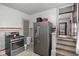 Well-equipped kitchen featuring stainless steel appliances, light gray cabinetry, and easy access to the stairway at 25 N Wayburn St, Indianapolis, IN 46229