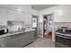 Galley kitchen with stainless steel appliances, a sink with granite countertops, and a view into the laundry room at 25 N Wayburn St, Indianapolis, IN 46229