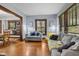 Cozy living room featuring hardwood floors, gray sofas, and natural light streaming through wood-slat blinds at 25 N Wayburn St, Indianapolis, IN 46229