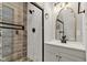 Updated bathroom featuring stylish tile, modern fixtures, a glass shower door and a decorative mirror above the vanity at 257 N Tacoma Ave, Indianapolis, IN 46201