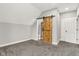 Charming bedroom with gray carpet, a wooden barn door leading to the ensuite bathroom, and ample natural light at 257 N Tacoma Ave, Indianapolis, IN 46201