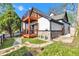 Charming two-story home with a stone foundation, white siding, a wood balcony, and a small front yard at 257 N Tacoma Ave, Indianapolis, IN 46201
