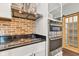 Modern kitchen features stainless steel appliances, brick backsplash, granite countertops, and a stainless steel range hood at 257 N Tacoma Ave, Indianapolis, IN 46201