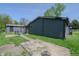 Exterior view of the backyard and home featuring a covered patio, shed, and green space at 2658 S Rybolt Ave, Indianapolis, IN 46241