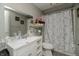 A clean, updated bathroom with a bright white vanity, decorative mirror, and a shower with stylish curtain at 2658 S Rybolt Ave, Indianapolis, IN 46241