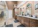Bright bathroom featuring double sinks with granite countertops, tile floors, and an adjacent glass shower at 2733 Foxborough Dr, Greenwood, IN 46143