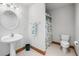 Comfortable bathroom with pedestal sink, shower and toilet with a stylish green accent at 2733 Foxborough Dr, Greenwood, IN 46143