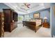 Well-lit bedroom showcasing a dark wood bed frame, a sitting area with a view, and an elegant ceiling fan at 2733 Foxborough Dr, Greenwood, IN 46143