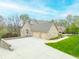 Elegant brick home with a spacious three-car garage, concrete driveway and beautifully landscaped front yard at 2733 Foxborough Dr, Greenwood, IN 46143