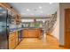Wet bar with wooden cabinets, granite countertop, wine rack, hardwood flooring, and an open staircase at 2733 Foxborough Dr, Greenwood, IN 46143