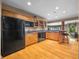 Kitchen with granite countertops, wooden cabinets, black appliances, and hardwood flooring at 2733 Foxborough Dr, Greenwood, IN 46143