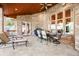 Spacious covered patio featuring outdoor dining and lounging areas, a wood ceiling, and a brick exterior at 2733 Foxborough Dr, Greenwood, IN 46143