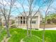 Multi-story home featuring balconies, lush lawn, and stone facade with mature trees and landscaping at 2733 Foxborough Dr, Greenwood, IN 46143