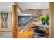 Elegant staircase with hardwood steps and a bar featuring seating, creating a seamless flow between levels at 2733 Foxborough Dr, Greenwood, IN 46143