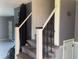 Carpeted stairway featuring decorative wrought iron railings and white risers and stringers at 3008 N Michigan Rd, Shelbyville, IN 46176