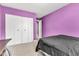 Bedroom featuring purple walls, carpet floor, white closets, and a double bed with black sheets at 301 S B St, Thorntown, IN 46071