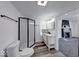 Modern bathroom features sleek glass shower, stylish vanity, and views to the living room fireplace at 3132 Indianapolis Ave, Indianapolis, IN 46208
