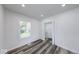 Bright bedroom with a laundry room, wood floors, and a window at 3132 Indianapolis Ave, Indianapolis, IN 46208
