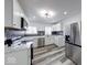 White kitchen featuring stainless steel appliances, white cabinets, marble countertops, and tile backsplash at 3132 Indianapolis Ave, Indianapolis, IN 46208