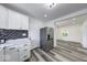 A well-lit kitchen featuring stainless steel appliances, white cabinets, and wood-style flooring at 3132 Indianapolis Ave, Indianapolis, IN 46208