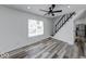 Bright living room featuring gray-tone floors, a modern ceiling fan, and a staircase at 3132 Indianapolis Ave, Indianapolis, IN 46208
