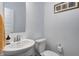 Well-lit half bathroom features a pedestal sink, toilet, and modern fixtures with neutral tones at 3148 Hawking Ct, Danville, IN 46122