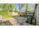 Backyard area with a concrete patio, grassy area, and a large trash bin at 3322 W 22Nd St, Indianapolis, IN 46222