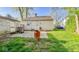View of the backyard with a small, grassy area, a small concrete patio, and a detached garage at 3322 W 22Nd St, Indianapolis, IN 46222