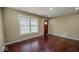 Inviting living room with wood floors, natural light from the window, and an exterior door at 3322 W 22Nd St, Indianapolis, IN 46222