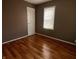 A well-lit room featuring hardwood floors, a white door, and a bright window at 3541 Orchard Ave, Indianapolis, IN 46218