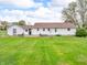 Large grassy backyard featuring patio and stone features at rear of one story home at 389 E State Road 42, Mooresville, IN 46158
