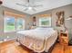 Comfortable bedroom with ceiling fan, two windows, and wood floors offers a serene and well-lit retreat at 389 E State Road 42, Mooresville, IN 46158