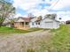 Home with brick accents and light siding features an attached garage and gravel drive at 389 E State Road 42, Mooresville, IN 46158