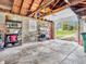 Spacious garage with open door, cinder block walls, and exposed wood beam ceiling provides ample storage and workspace at 389 E State Road 42, Mooresville, IN 46158
