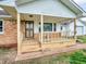 View of home's front porch with wood flooring and steps, siding, and front door at 389 E State Road 42, Mooresville, IN 46158