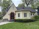 Charming home featuring a decorative wrought-iron door, manicured landscaping, and a cozy bench at 421 W 44Th St, Indianapolis, IN 46208