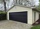 Side view of garage shows the beige siding with black garage door at 421 W 44Th St, Indianapolis, IN 46208