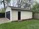 Detached garage features a black garage door and a pedestrian door for convenient access at 421 W 44Th St, Indianapolis, IN 46208