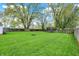 Spacious, green backyard featuring a fire pit and mature trees at 429 E Main St, Whiteland, IN 46184