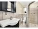 Well-lit bathroom featuring tile surround, black cabinets, sink, toilet and walk-in shower at 429 E Main St, Whiteland, IN 46184