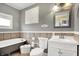 Charming bathroom featuring tub, toilet, sink with white cabinets, tiled floor and walls at 429 E Main St, Whiteland, IN 46184