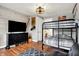 Bright bedroom with a bunk bed, wood-look accent wall, dresser, and modern light fixture at 429 E Main St, Whiteland, IN 46184