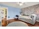 Comfortable bedroom featuring brick accent wall, hardwood floors, and ample natural light at 429 E Main St, Whiteland, IN 46184