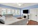 Bright bedroom featuring hardwood floors, fireplace, television, ceiling fan, and three windows at 429 E Main St, Whiteland, IN 46184