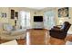 Bright living room features hardwood floors, many windows with curtains, and plenty of comfortable seating at 429 E Main St, Whiteland, IN 46184
