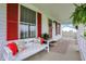 Relaxing front porch with a white bench seat and decorative pillows on a charming home at 429 E Main St, Whiteland, IN 46184